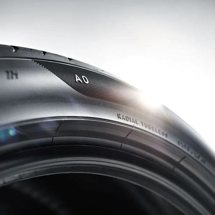 Close-up of a camera lens with focus on the text "AO" against a bright background.