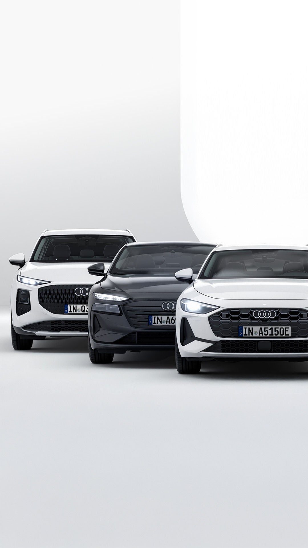 Frontalansicht eines weißen Audi A5 und eines schwarzen Audi A6 in heller lichtdurchfluteter Atmosphäre