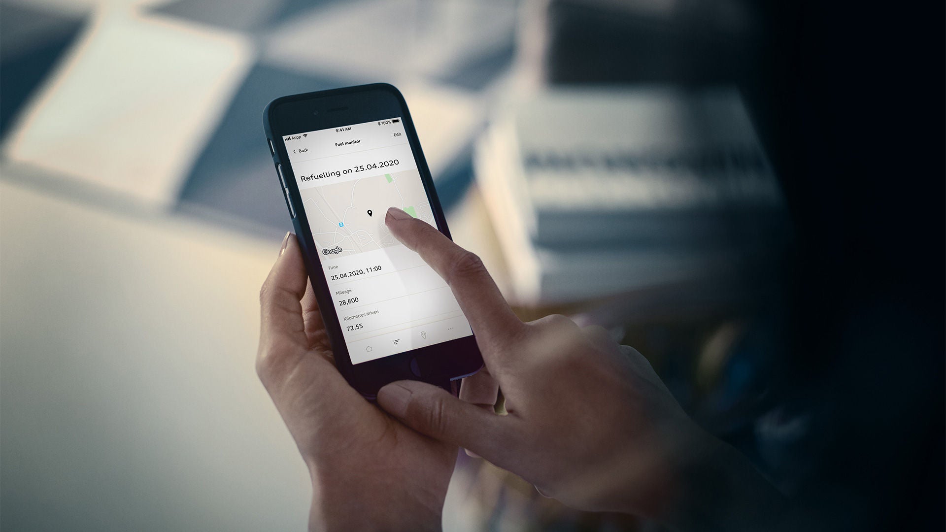 A closeup of a person using an Audi app on their smartphone.