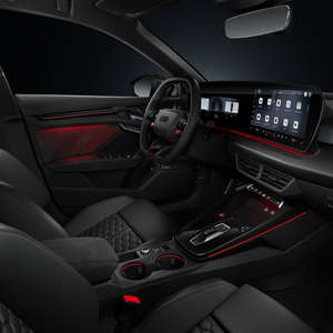 Blick von der Beifahrerseite auf das Cockpit mit Sportkonturlenkrad, Mittelkonsole, digitale Displays und das Ambiente-Licht.