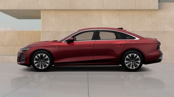 A red sedan features modern design elements, showcased against a minimalist concrete backdrop.