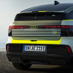 A highly magnified close-up of the rear of the Audi A2 e-tron with yellowish vinyl wrap.