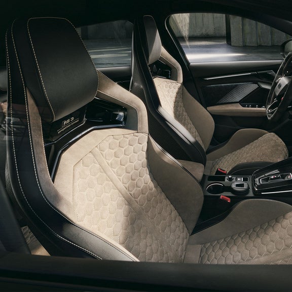 Gros plan sur les sièges baquets RS avec inscription « RS competition limited » et surpiqûres en nid d'abeille blanc gingembre.