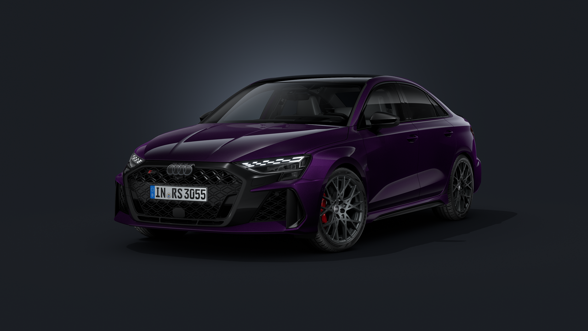De Audi RS 3 Berline met gepersonaliseerde lakafwerking ‘Merlin pareleffect’ tegen een donkere achtergrond.