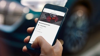 Man holding smartphone with open myAudi app