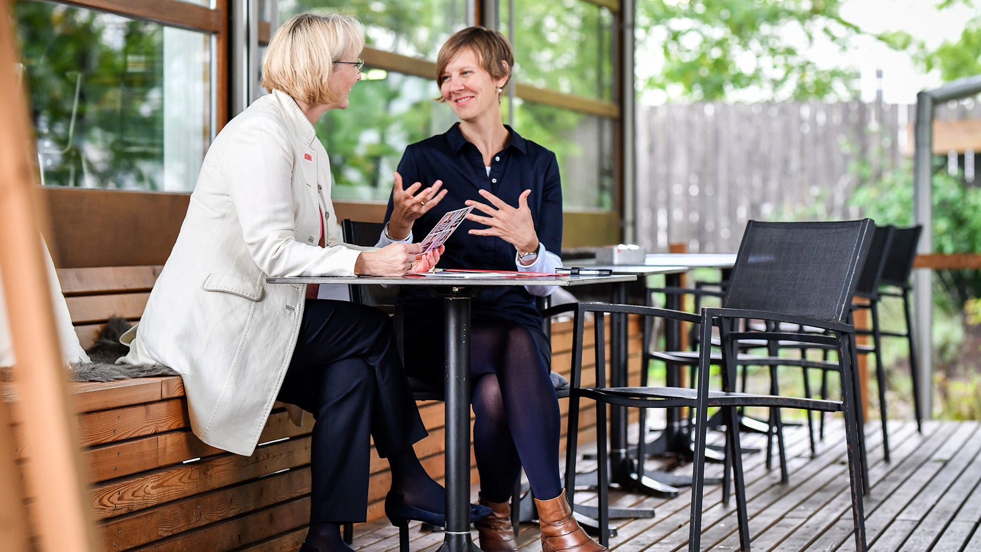 Two people sit on a bench and talk