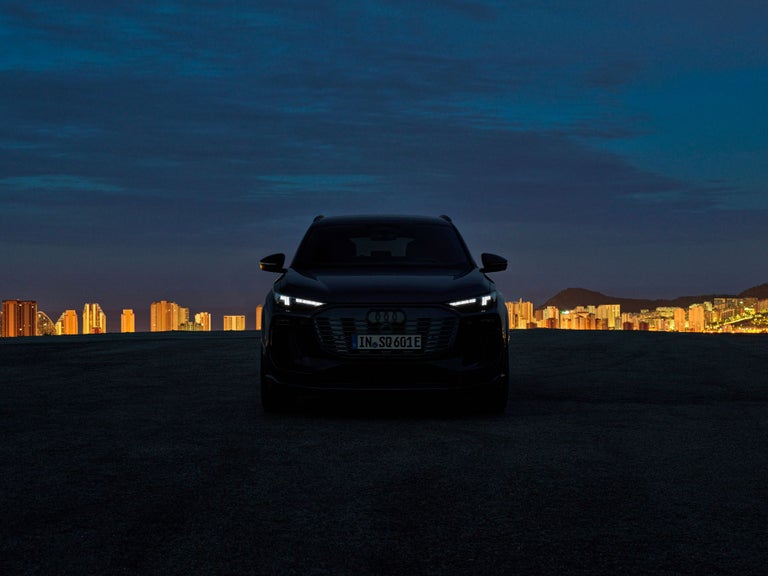 Die Scheinwerfer eines Audi Modells leuchten in der Dunkelheit