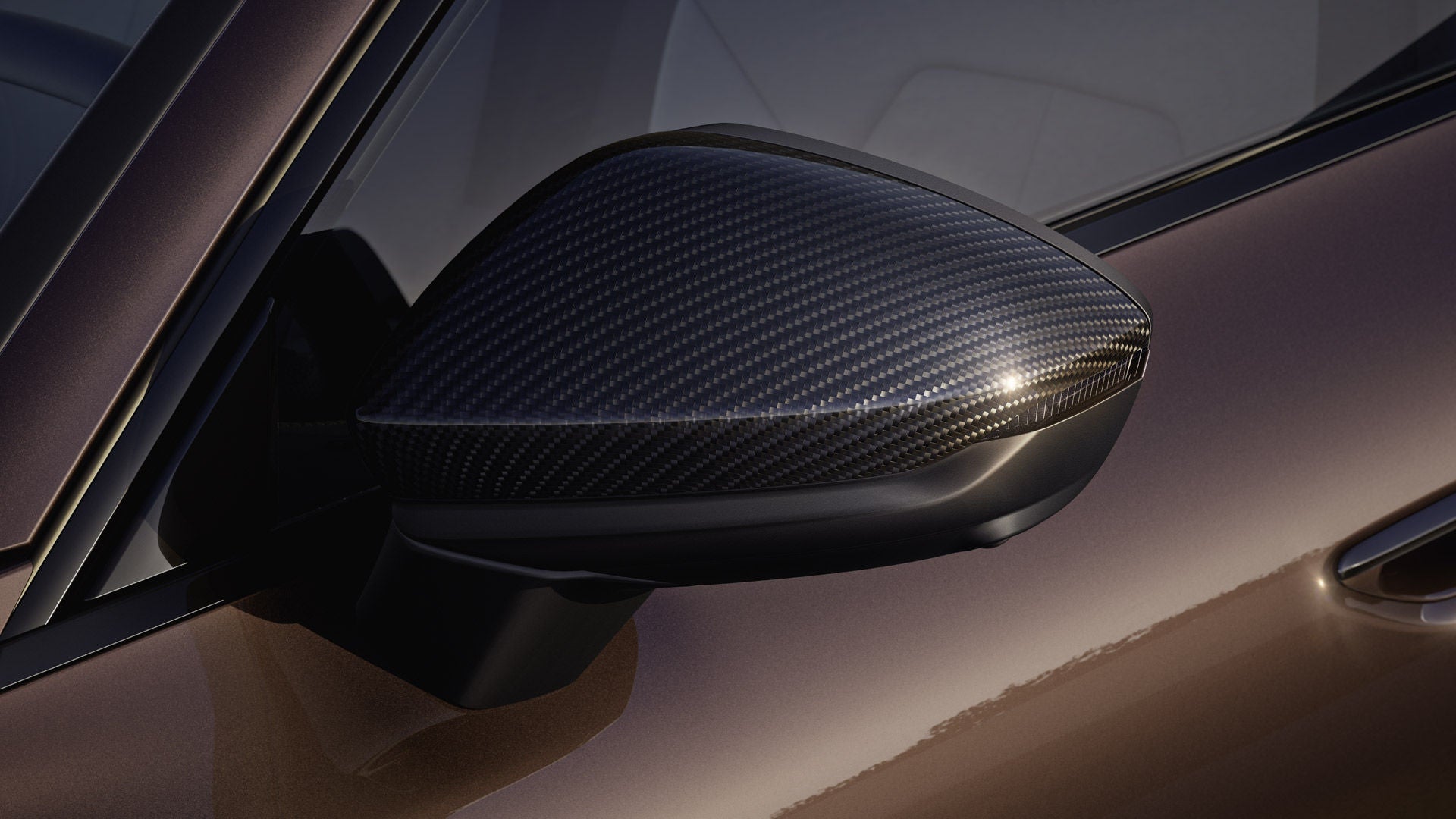 Närbild på den vänstra ytterbackspegeln på A6 Avant. Spegeln har ett svart kolfiberhölje.