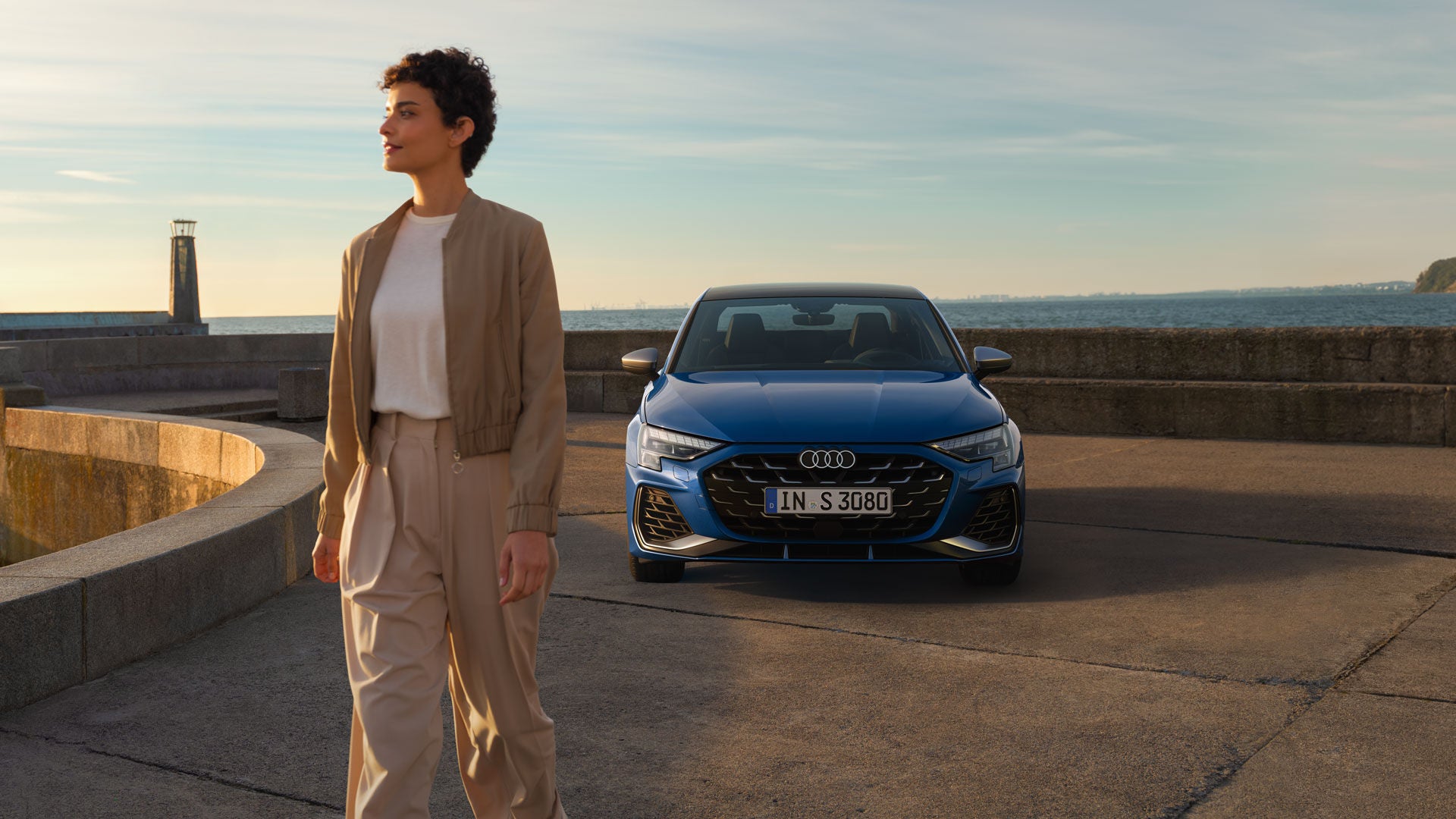 Eine Frau läuft vor einem blauen Audi