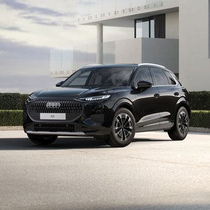 Schwarzer Audi Q3 SUV vor einem modernen weißen Gebäude.