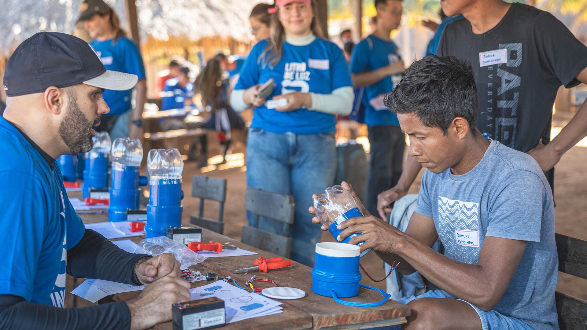 Ein junger Mann bastelt mit anderen Helfern Lichtquellen.