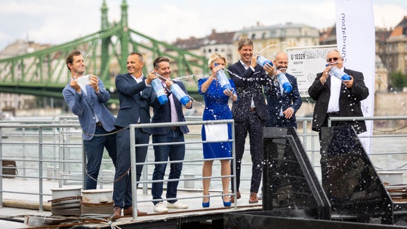 People celebrate on a footbridge