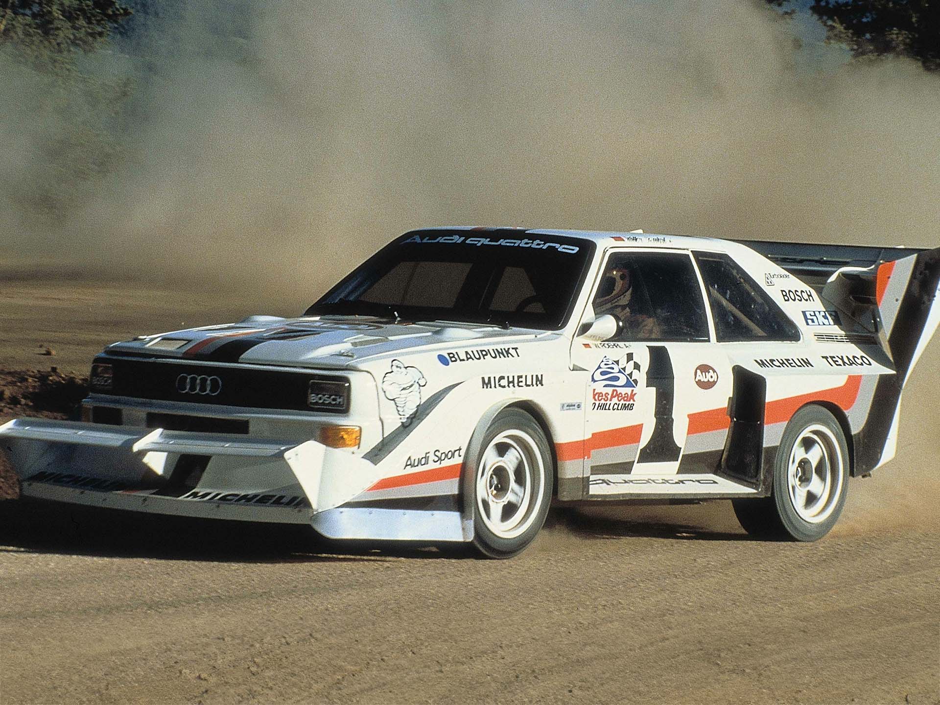 Das Foto zeigt ein Audi Sport quattro S1 E2 Rallyeauto auf Schotter beim Bergrennen am Pikes Peak in den USA 1987.