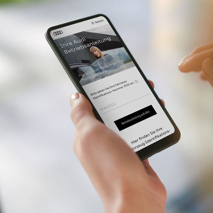 Smartphone zeigt eine Webseite zur Fahrzeug-Betriebsanleitung mit Eingabefeld für die Fahrzeug-Identifikations-Nummer