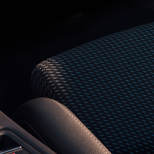 Close-up of Audi A3 Sportback seat and centre console, showing black and blue textured seat.