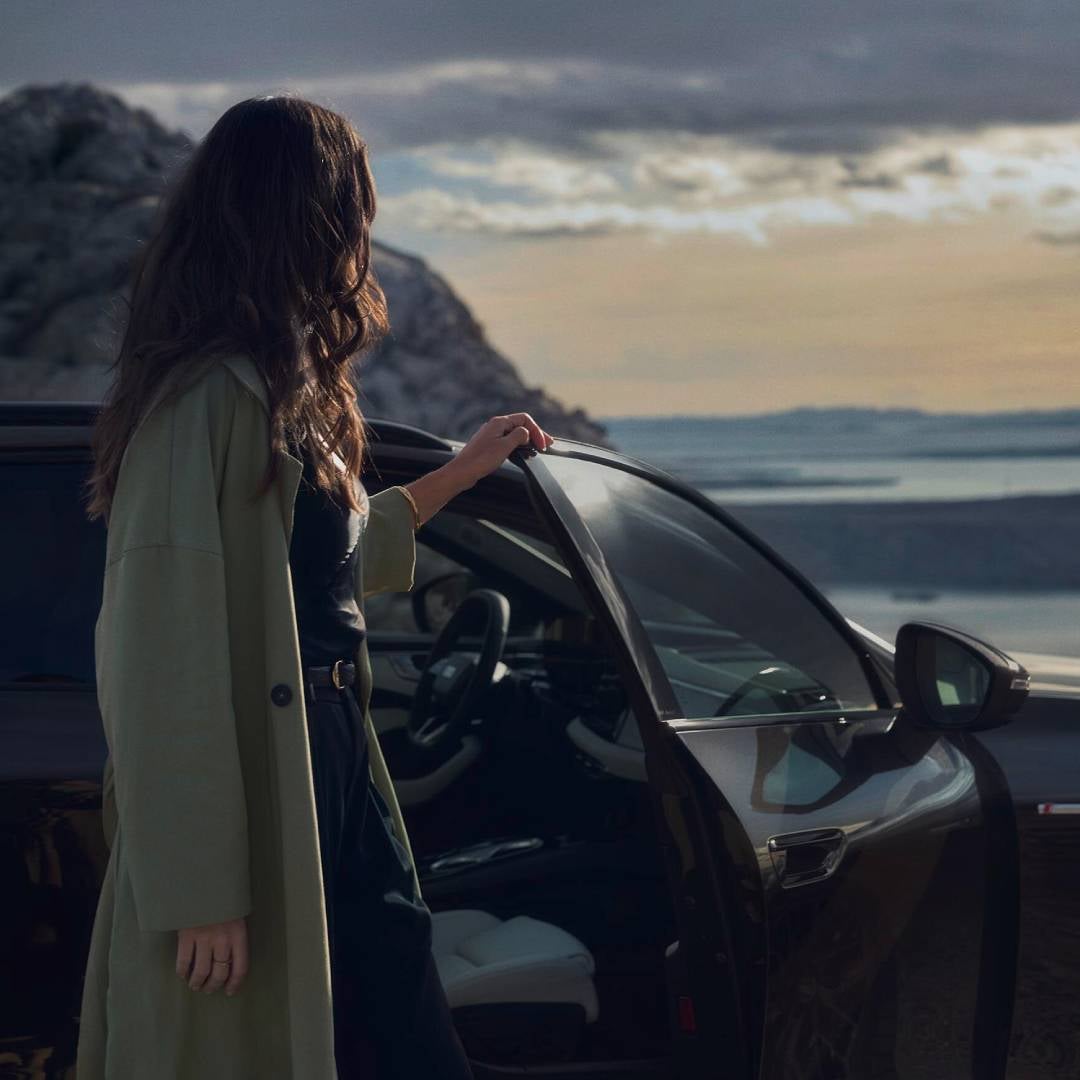 una donna rivolta verso l'interno di una vettura audi