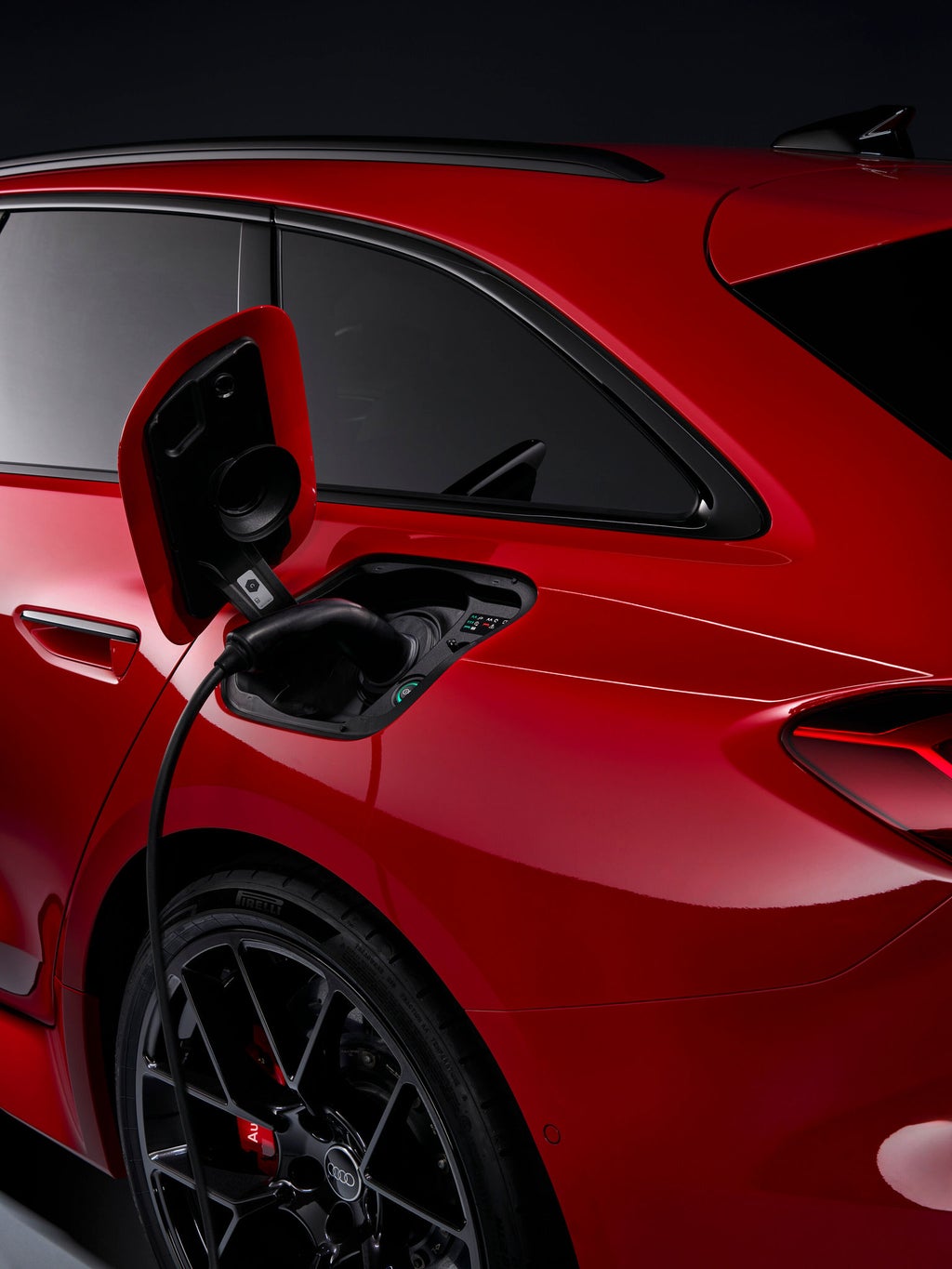 Focus on the rear of the RS 5 Avant, with a charging station in the background.