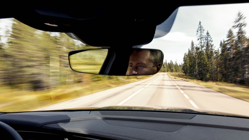 Stefan Sjöstrand sitter i bilen och tittar i backspegeln
