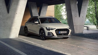 Ein weißer Audi A3 ist in einem modernen Gebäude geparkt.