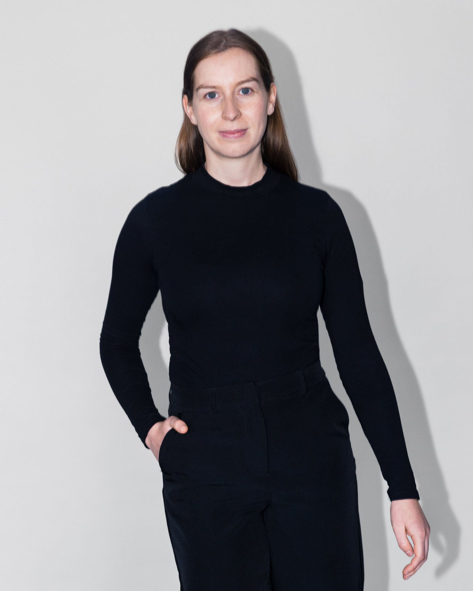 Portrait von Produktreferentin Annika Stößl vor einer weissen Wand.