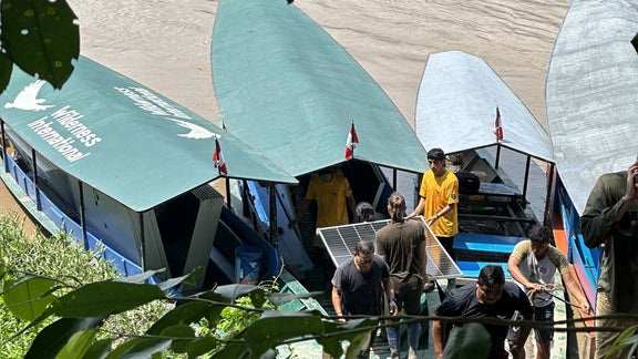 People load boats with solar panels