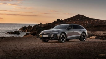 Audi A6 allroad quattro - Audi A6 allroad (plateau grey metallic) in side view at a rugged coastal landscape during sunset.