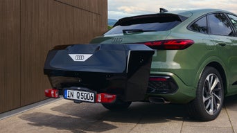 Audi verte équipée d'un coffre arrière noir.