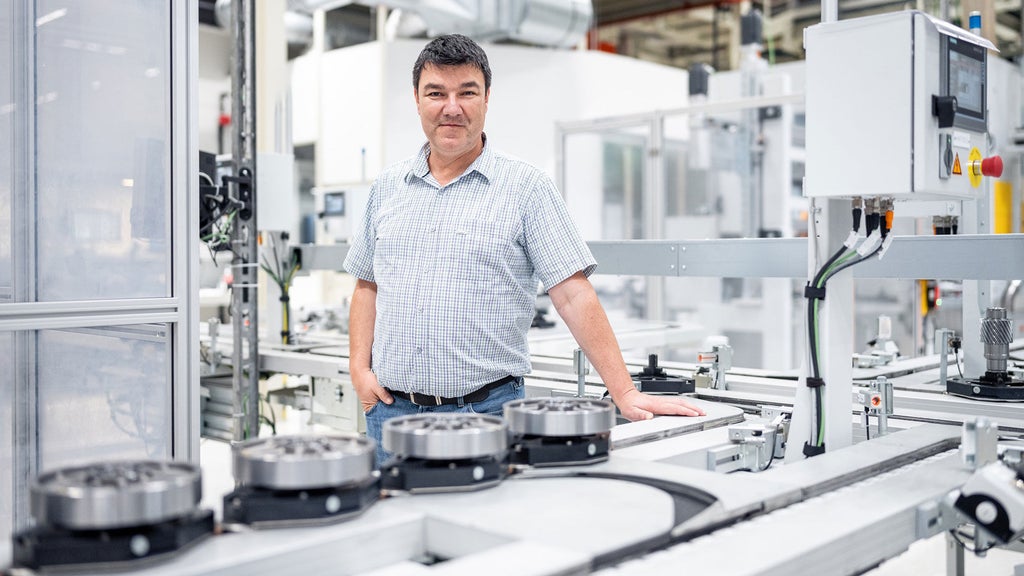 Attila Kovacs stands at a workstation in the workshop