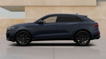 Dark blue Audi SQ8 SUV parked by a modern beige wall, viewed from the side with black windows and wheels.