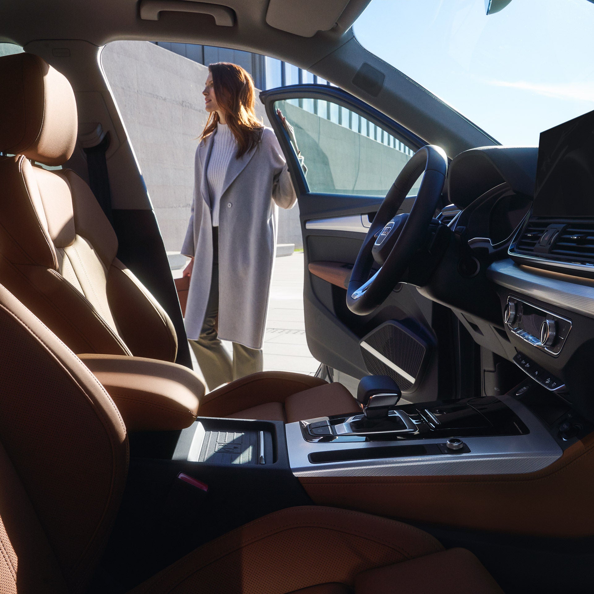  En kvinna som håller i en öppen bilddörr till förarplatsen