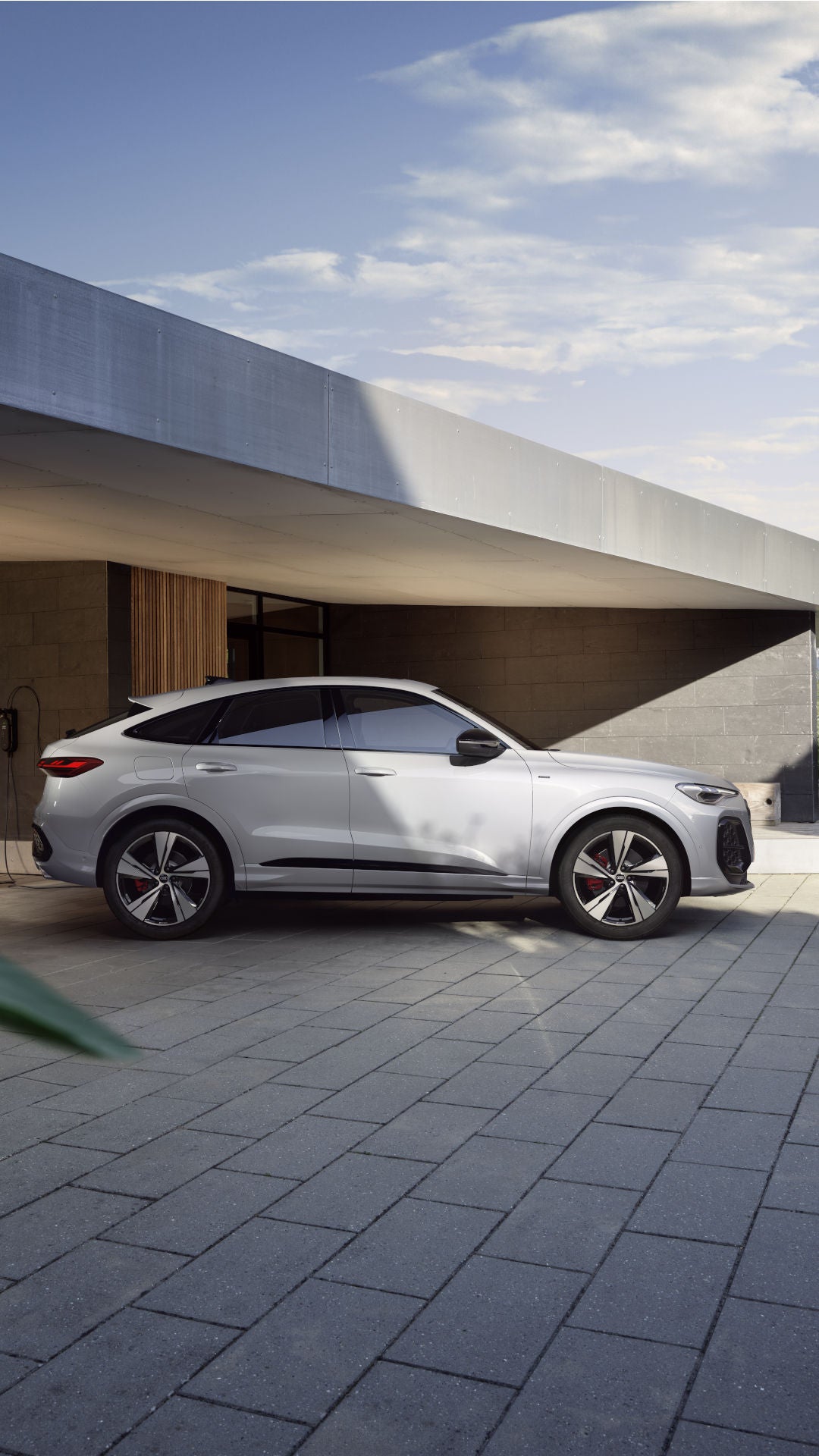Q5 Sportback e-hybrid staat geparkeerd voor een modern huis.