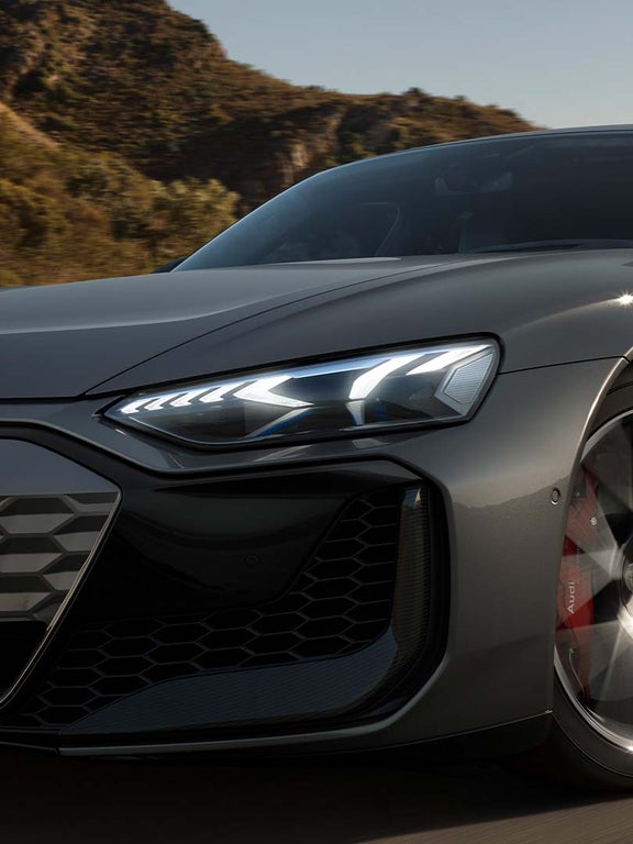 Nahaufnahme eines LED-Scheinwerfers eines Audi RS e-tron GT mit markantem Lichtdesign.