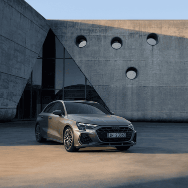 A modern Audi S3 Sportback car parked in front of a building with circular windows.