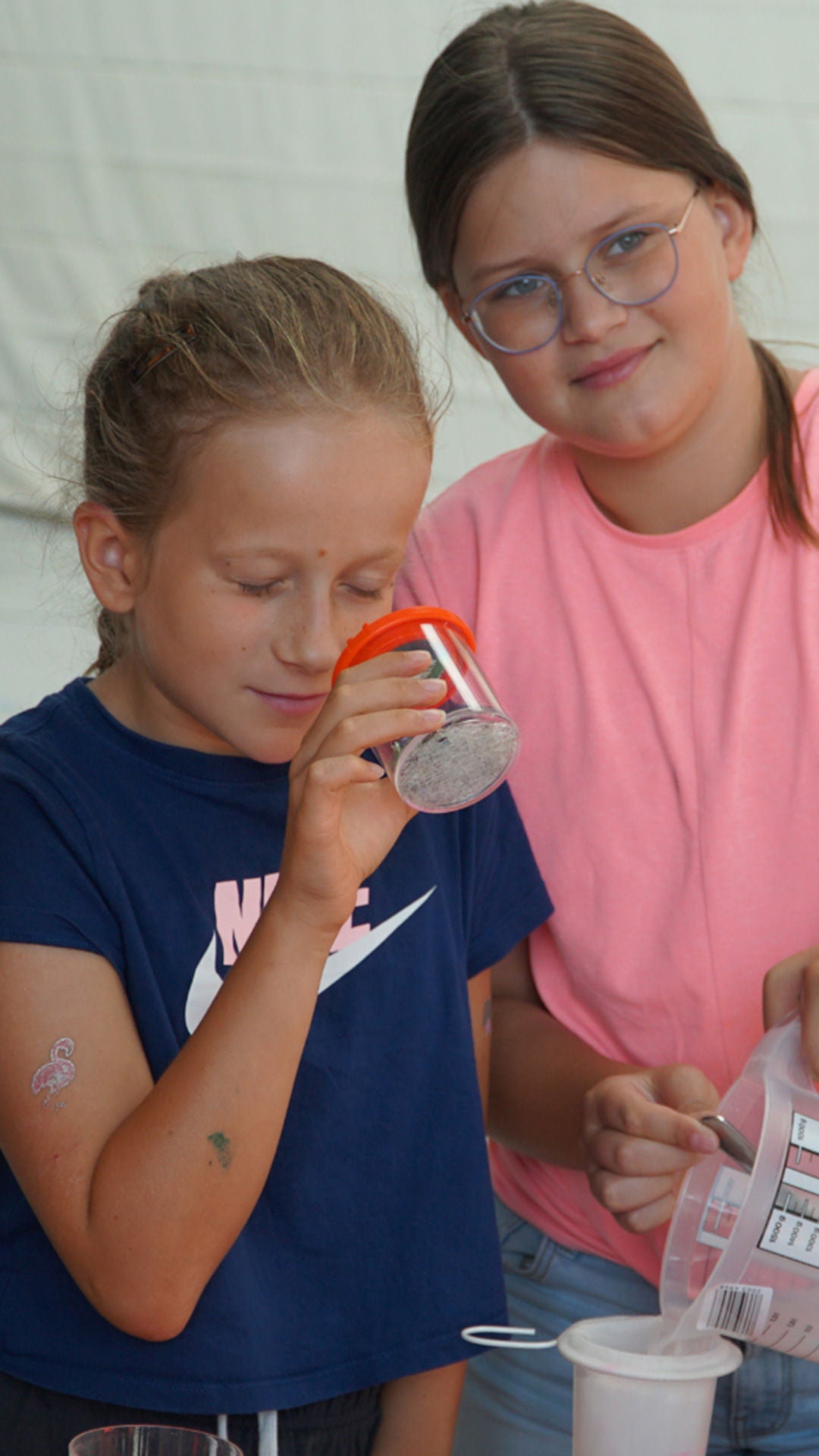 Children examine something in a magnifying glass.