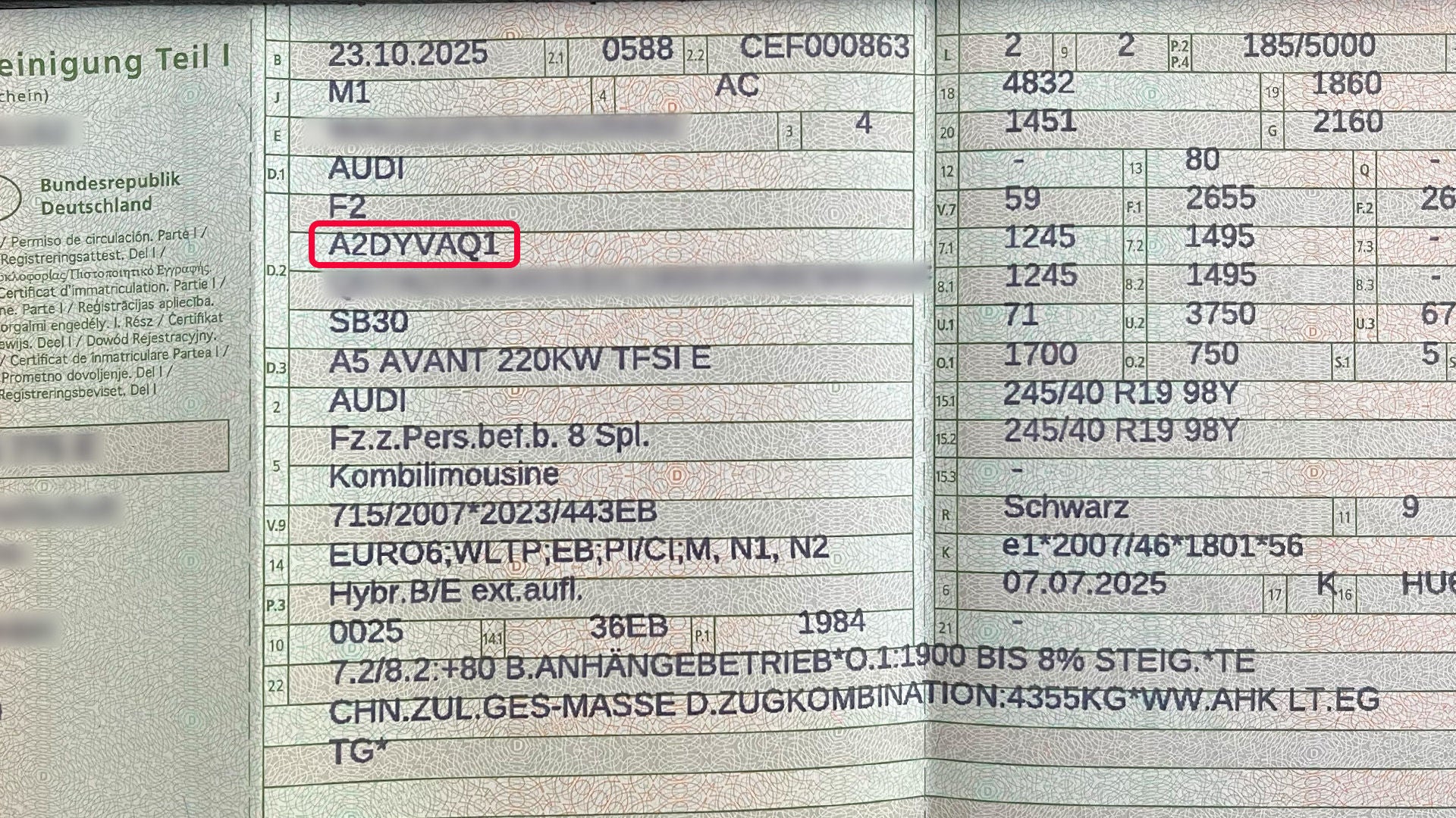 Nahaufnahme eines Fahrzeugscheins, in dem eine Motorennummer rot markiert hervorgehoben ist.