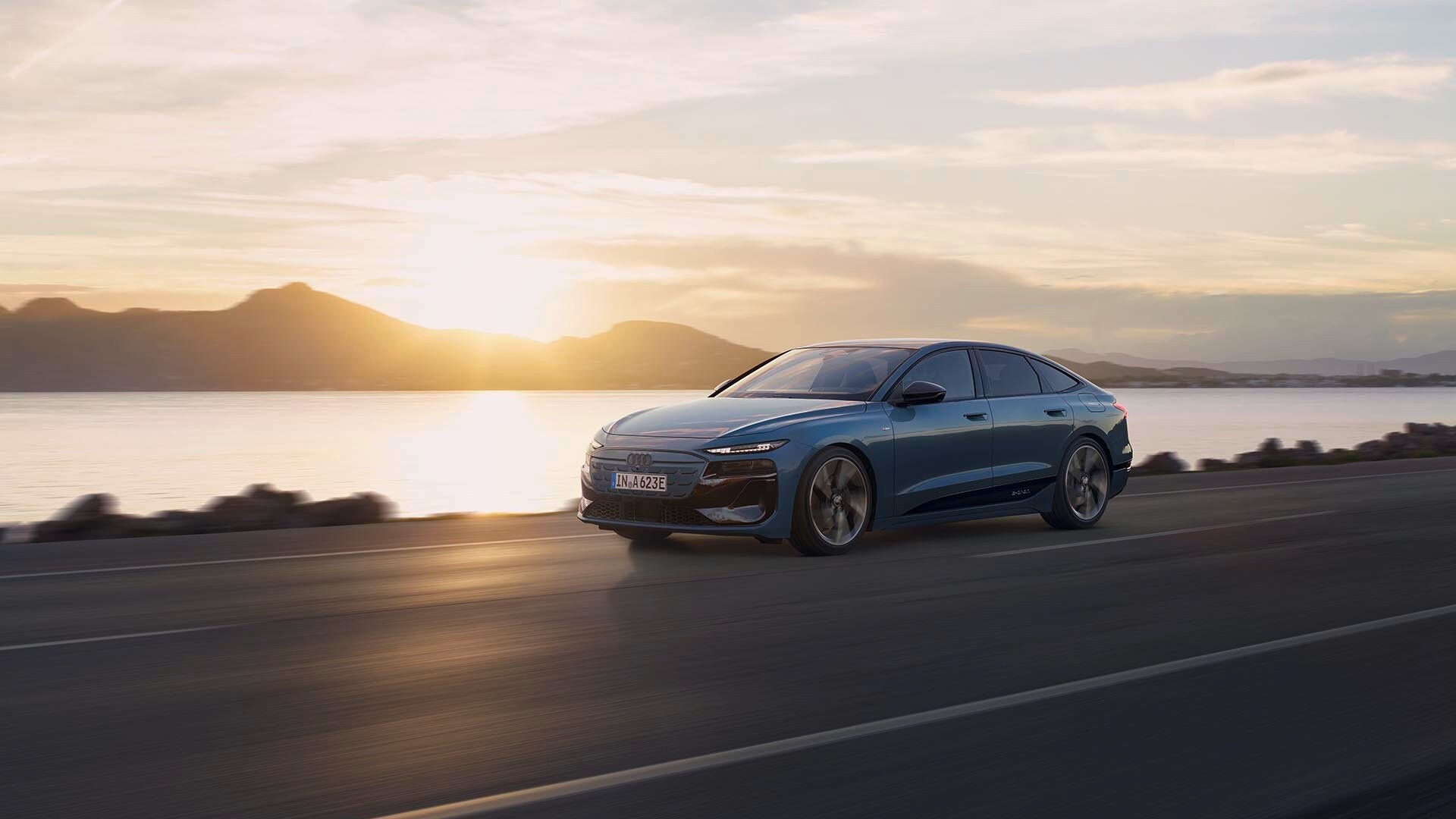 Driving Audi A6 Sportback e-tron performance in front of a setting sun.