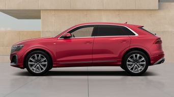 Red Audi Q8 SUV TFSI e parked by a modern beige wall, side view, with chrome trim and silver alloy wheels.