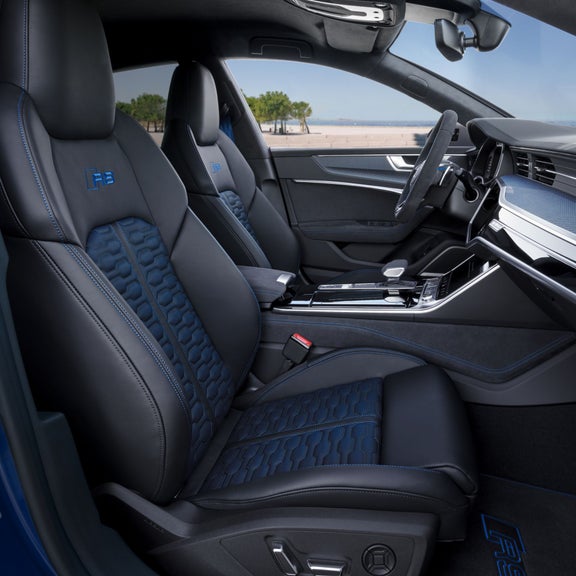 Car interior with blue accented black leather seats and modern dashboard.