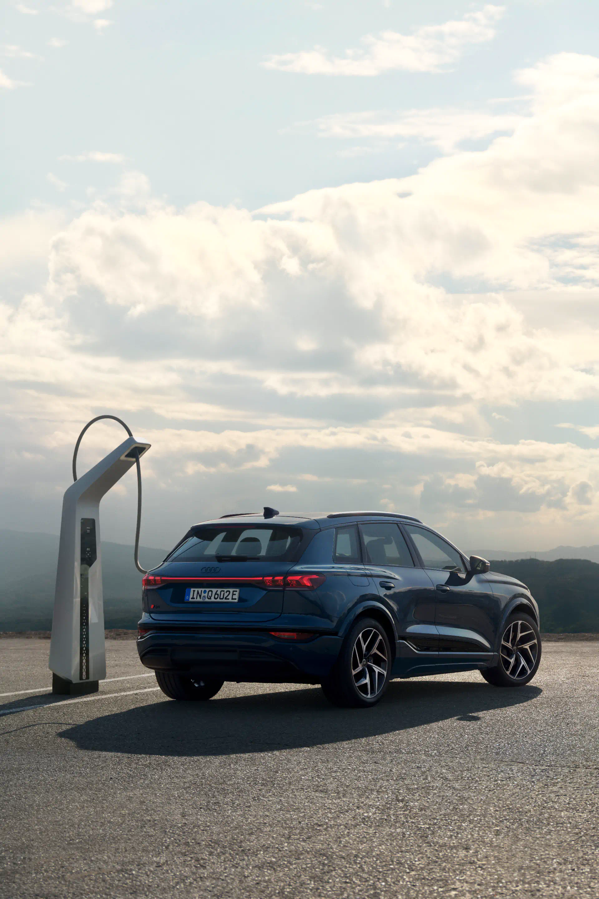 The Audi Q6-etron is pluged to a charging station.