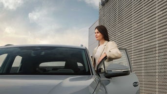 Frau stehend neben ihrem Audi