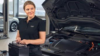 Audi service professional with an Audi car battery