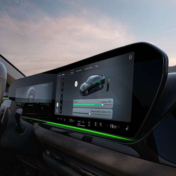 Nahaufnahme des Cockpits aus Beifahrerperspektive mit Fokus auf dem MMI-Display. Auf diesem wird der aktuelle Ladezustand sowie ein Slider zur Regelung der Reserve angezeigt.