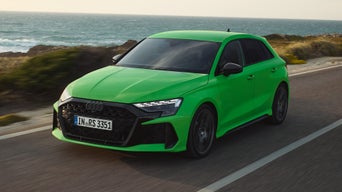 Schwarze Audi Ringe an der Front eines grünen Audi RS 3 Sportback