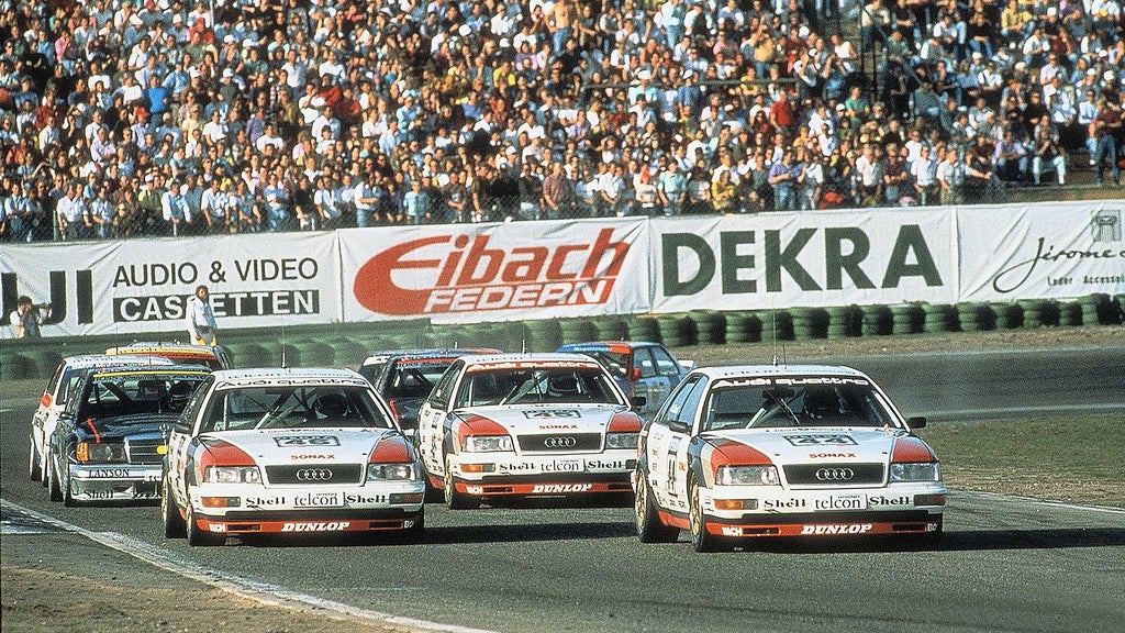 Das Foto zeigt drei Audi V8 quattro-Rennwagen auf der Strecke in Hockenheim 1990.