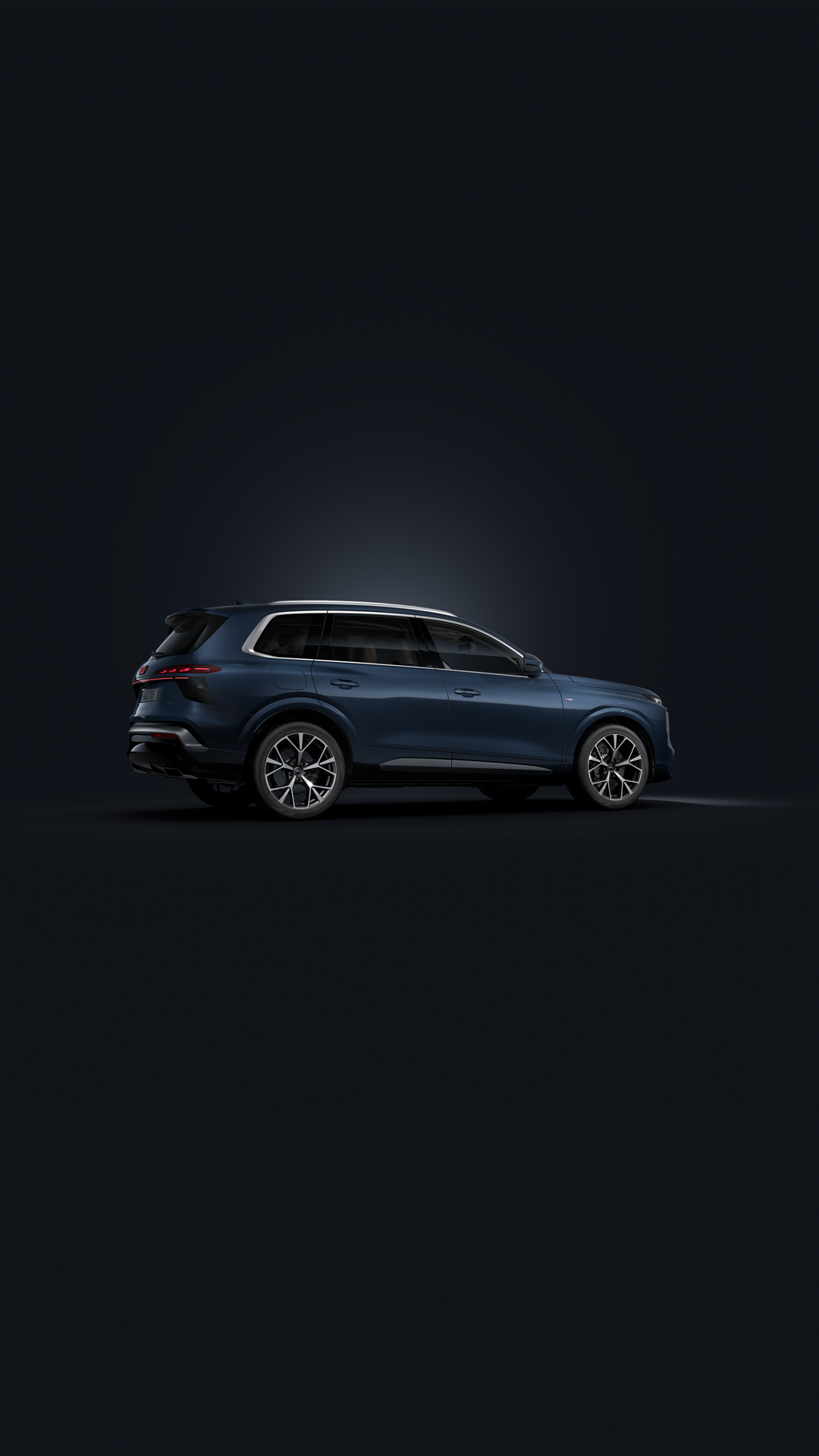 Vue de face en biais du SUV Audi Q7 sur fond sombre.