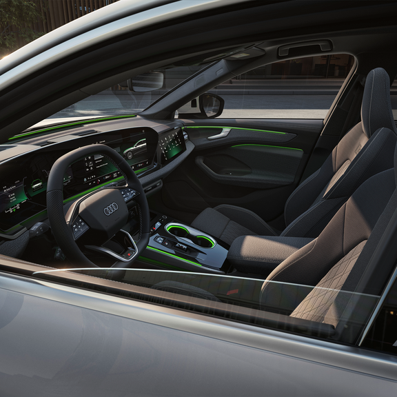 Audi car interior featuring modern design, high-tech dashboard displays, and vibrant green accents on the seats and console.