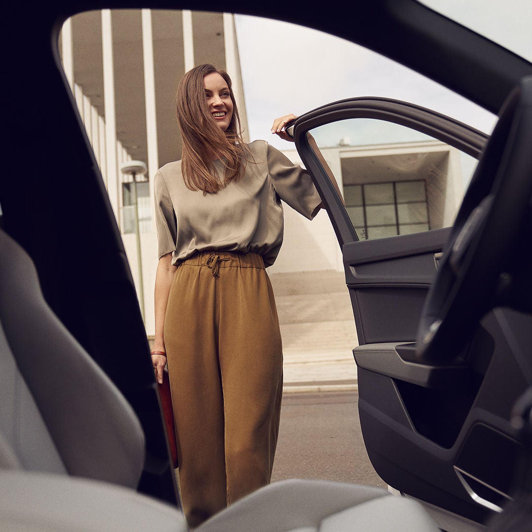 Innenansicht einer Frau, die die Autotür eines Audi öffnet