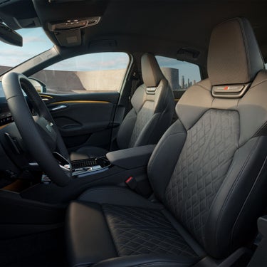 Vordersitze mit Rautenmuster und geprägtem S-Logo in schwarzem Innenraum eines Audi SQ6 Sportback e-tron.