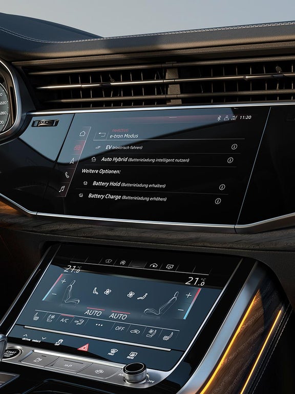 Nahaufnahme eines Touchscreens im Audi Q7 SUV TFSI e zeigt e-tron-Fahrmodi wie EV und Auto Hybrid.