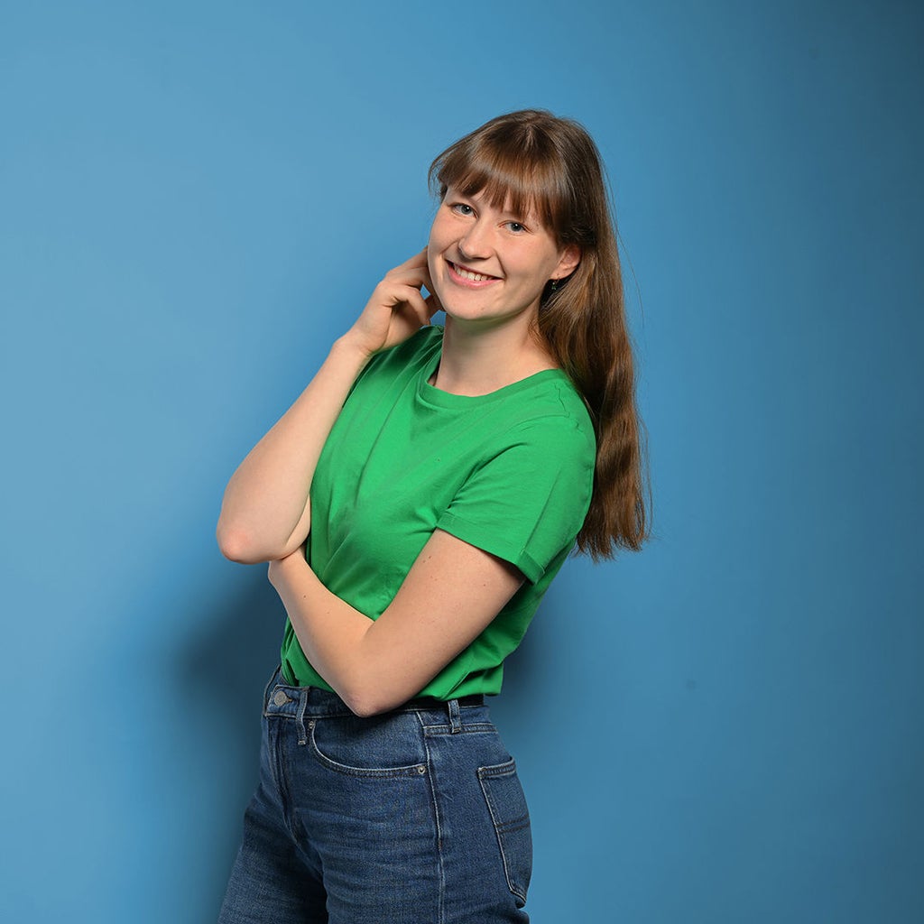 Josee lacht in die Kamera und hat eine Hand am Gesicht